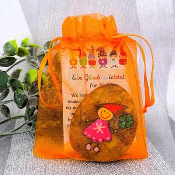 Glücksstein mit einer Geschenkkarte in einem Organzasäckchen