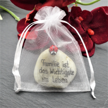 Glücksstein in einem weissem Organzasäckchen