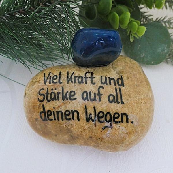 Blauer Trommelstein auf einen Stein geklebt mit einem Pruch